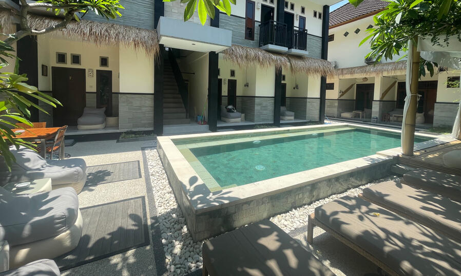 Swimming pool at Nomads Home Bali with lounge area and garden